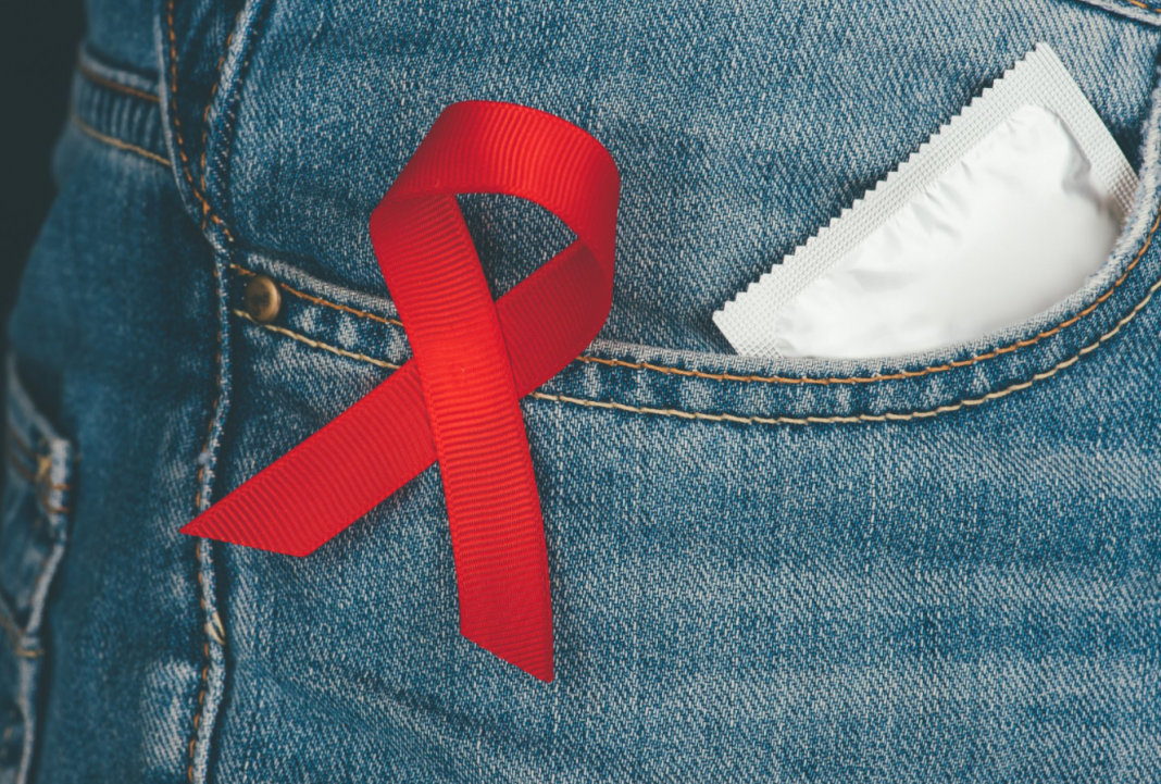 protection et éducation sexuelle préservatif et ruban rouge sida